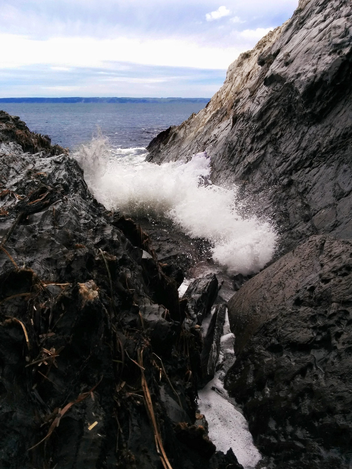 Surf crashing through the crags in the rock