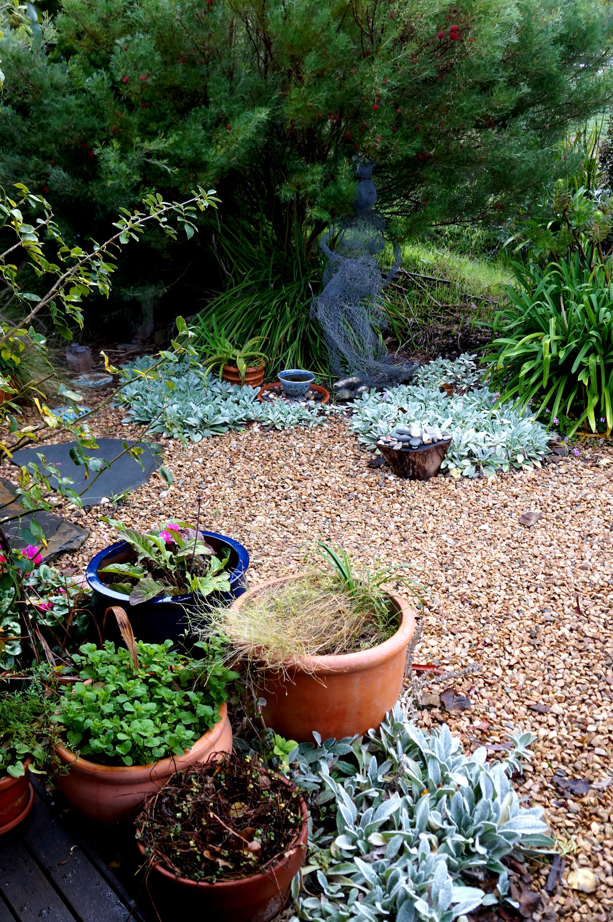 Detail shot of part of the front garden. It was a day or three before I noticed that underneath the canopy (behind the wire mesh woman), was a pond with fish.